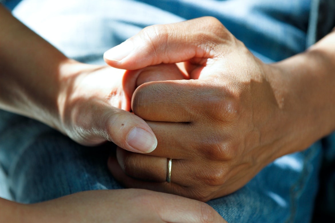 photo-1584515933487-779824d29309 aged care A younger hand holding an older hand with a blue background