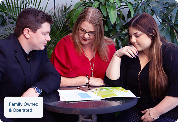 The Cassar family team looking at a brochure together at a table