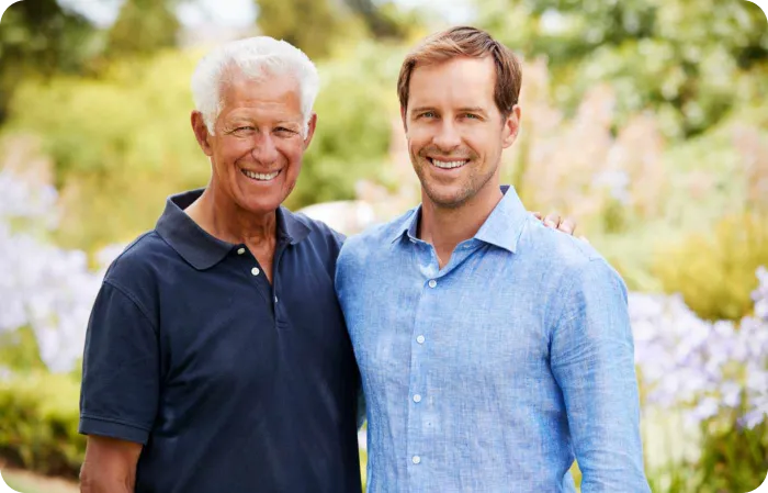 Father and son smiling in a garden
